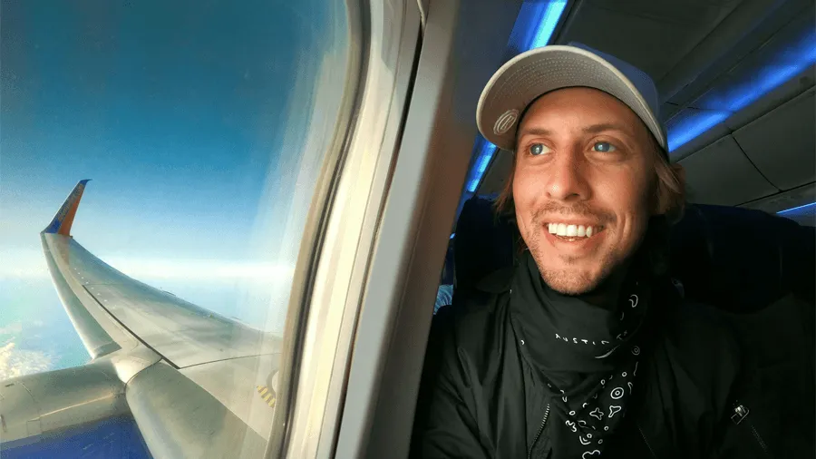 En man på ett flygplan som blickar ut i fönstret.