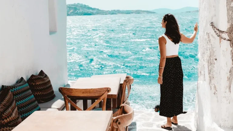 Kvinna som står på restaurang i Mykonos och testar på att öluffa i Grekland.