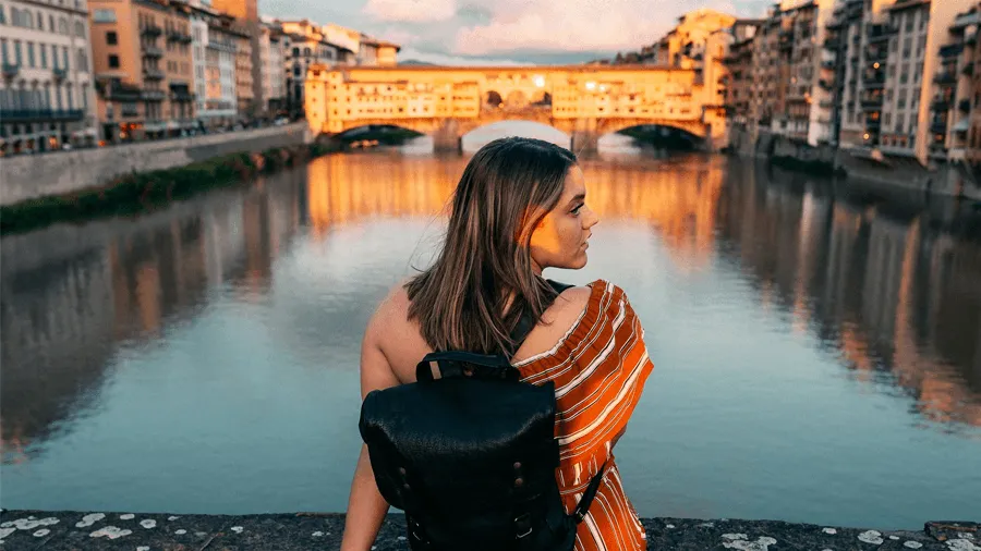Kvinna framför den kända bron Ponte Vecchio.