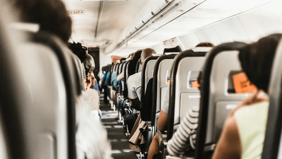 En flygplansgång fylld med passagerare.