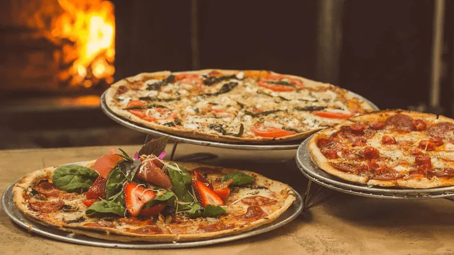 Tre pizzor med olika toppings.