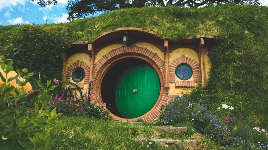 Ett hus på Hobbiton i Nya Zeeland med en rund grön dörr.