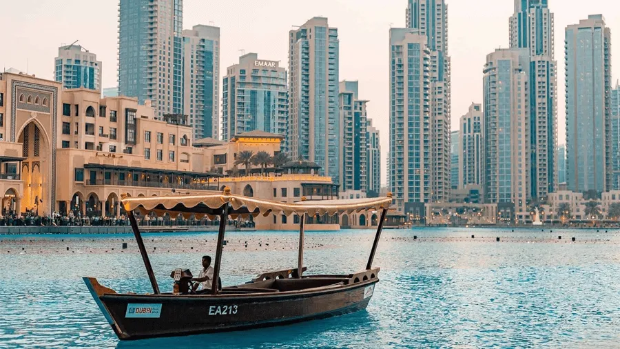 Båt på vattnet med staden Dubai i bakgrunden.
