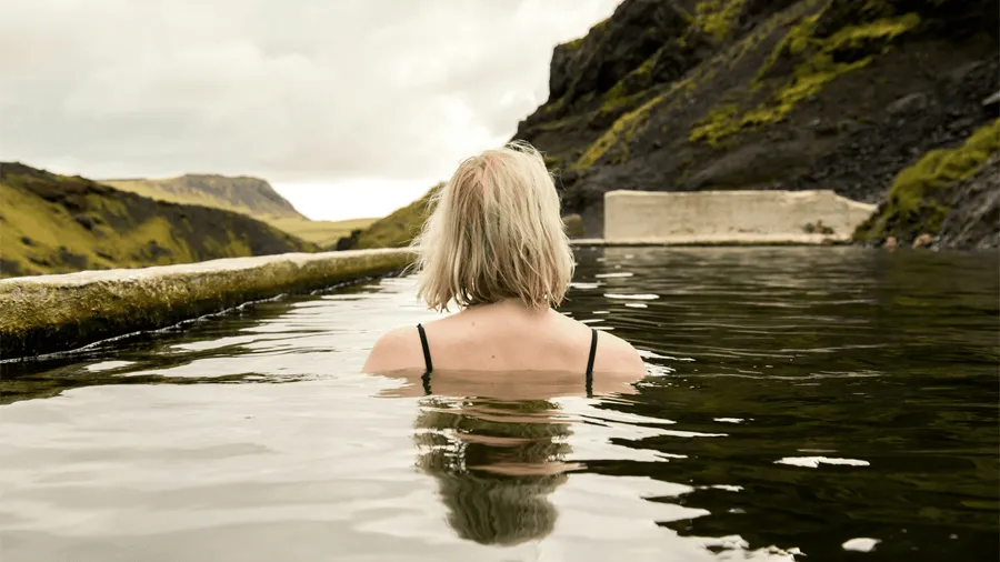 Kvinna i geotermisk pool på Island.