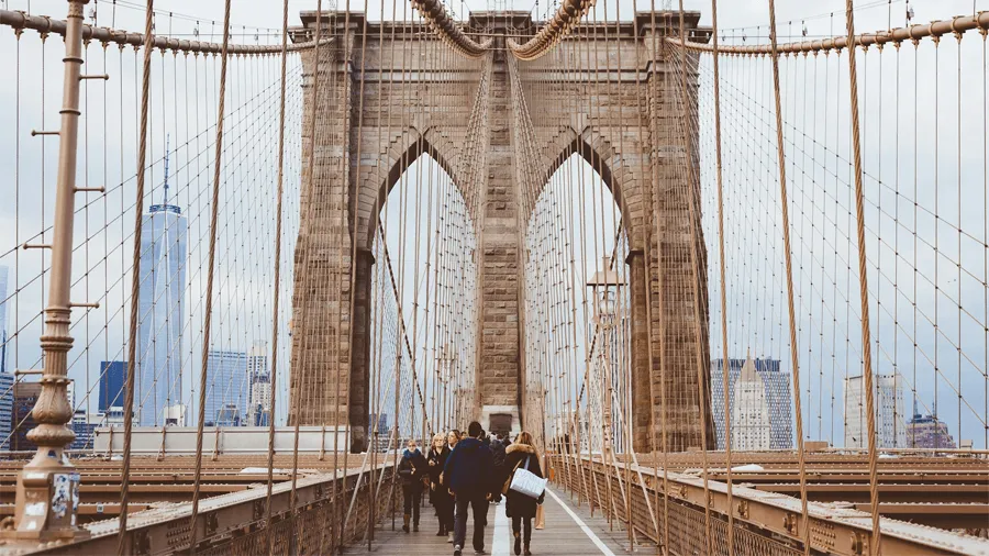 Folk som går på Brooklyn Bridge.
