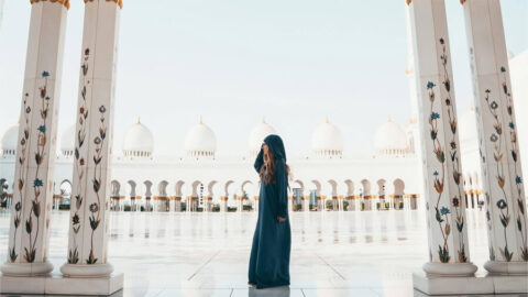 En kvinna vid en moské på sin Abu Dhabi resa.