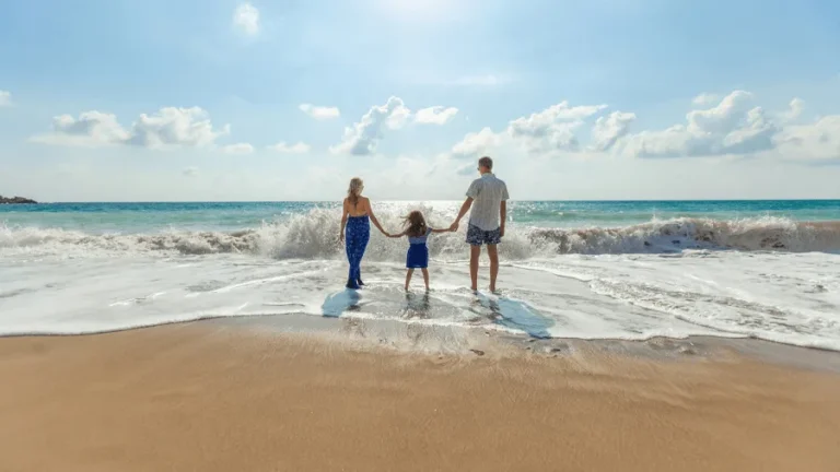 Barnfamilj på en sandstrand som åkt på solresor med all inclusive.
