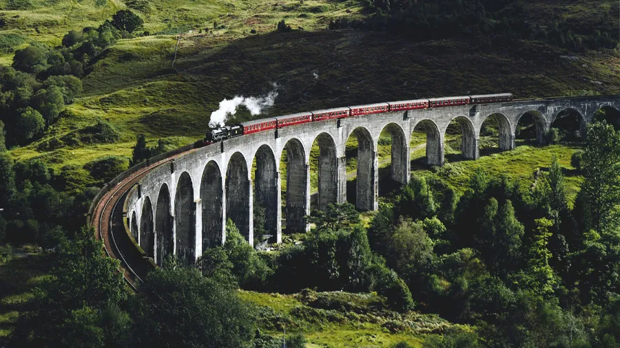 Tåg som åker vid Glenfinnan viaduct.