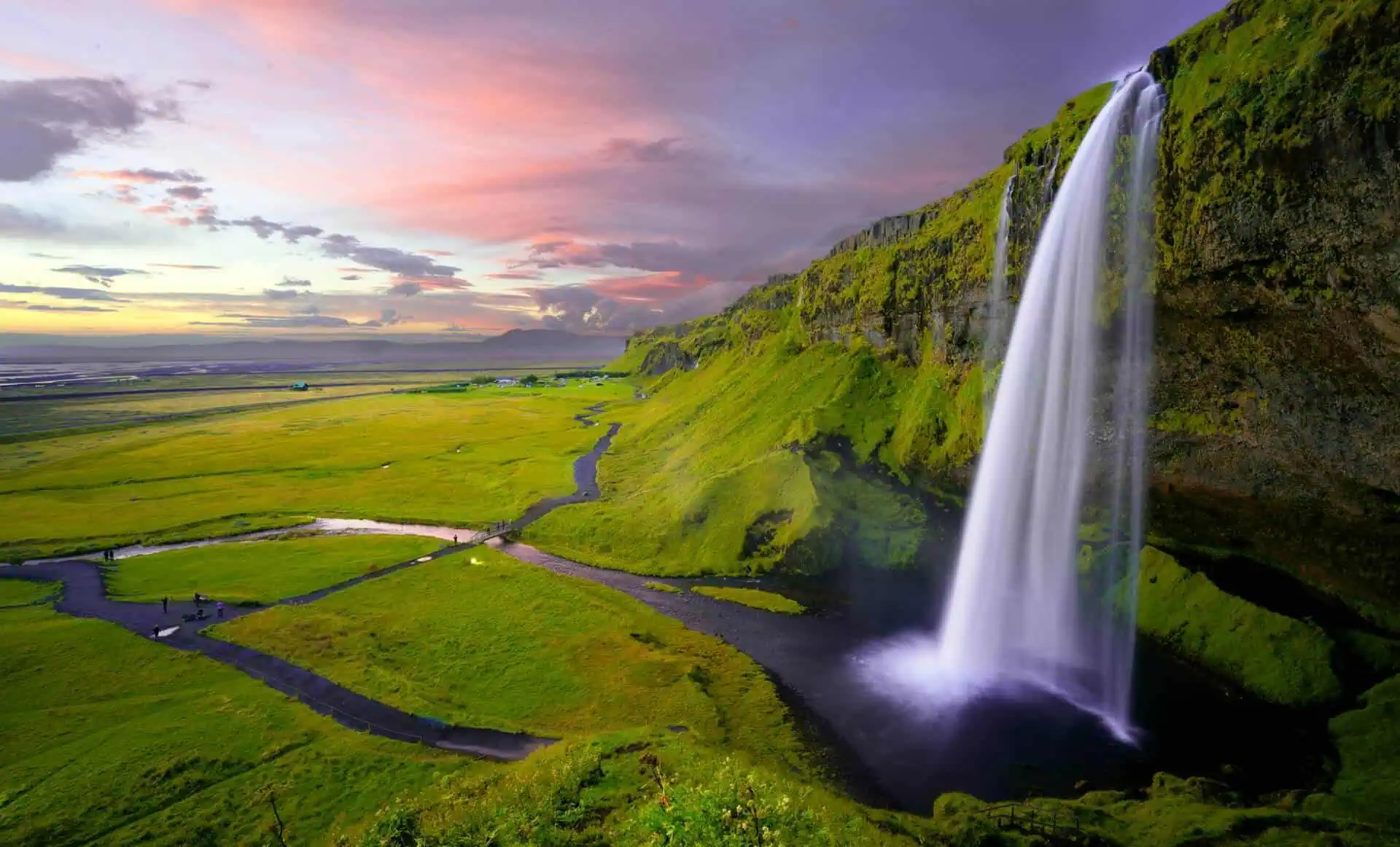 Vattenfallet Seljalandsfoss med en färgglad himmel i bakgrunden.