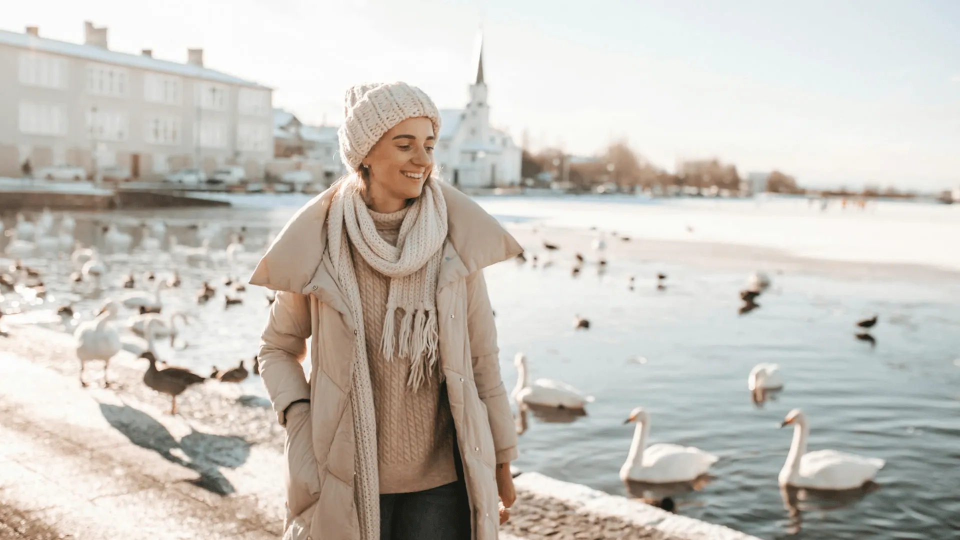 En kvinnlig turist med Reykjaviks frikyrka i bakgrunden.