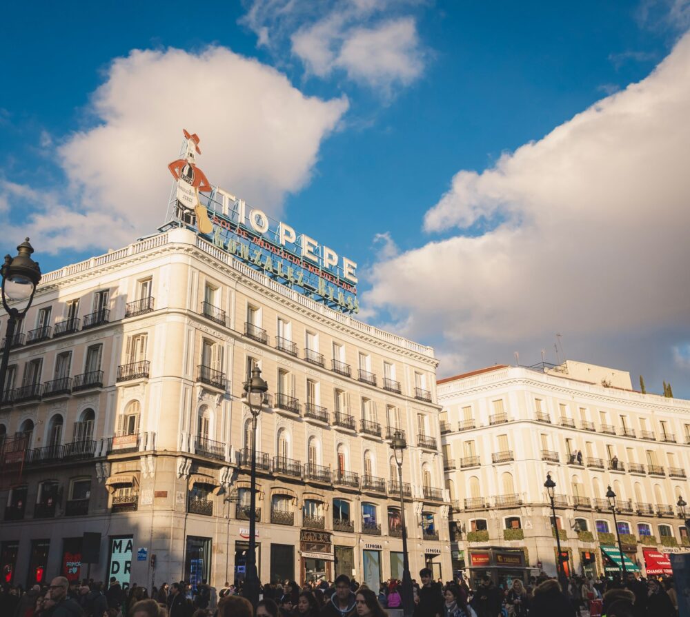 Livlig folkmangd pa Puerta del Sol i Madrid med Tio Pepe-skylten