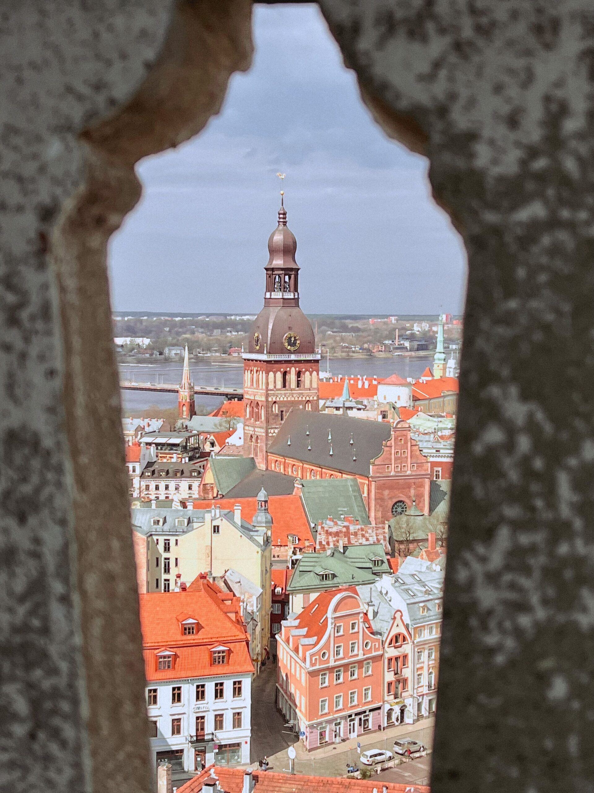 Vy mot Rigas domkyrkotorn genom ett stenvalv i gamla stan