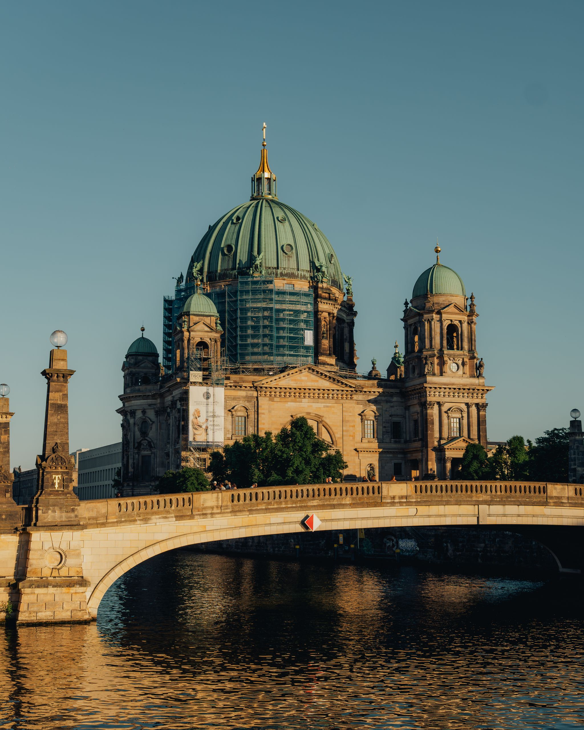 Berliner Dom med grön kupol vid Spree i solnedgångsljus