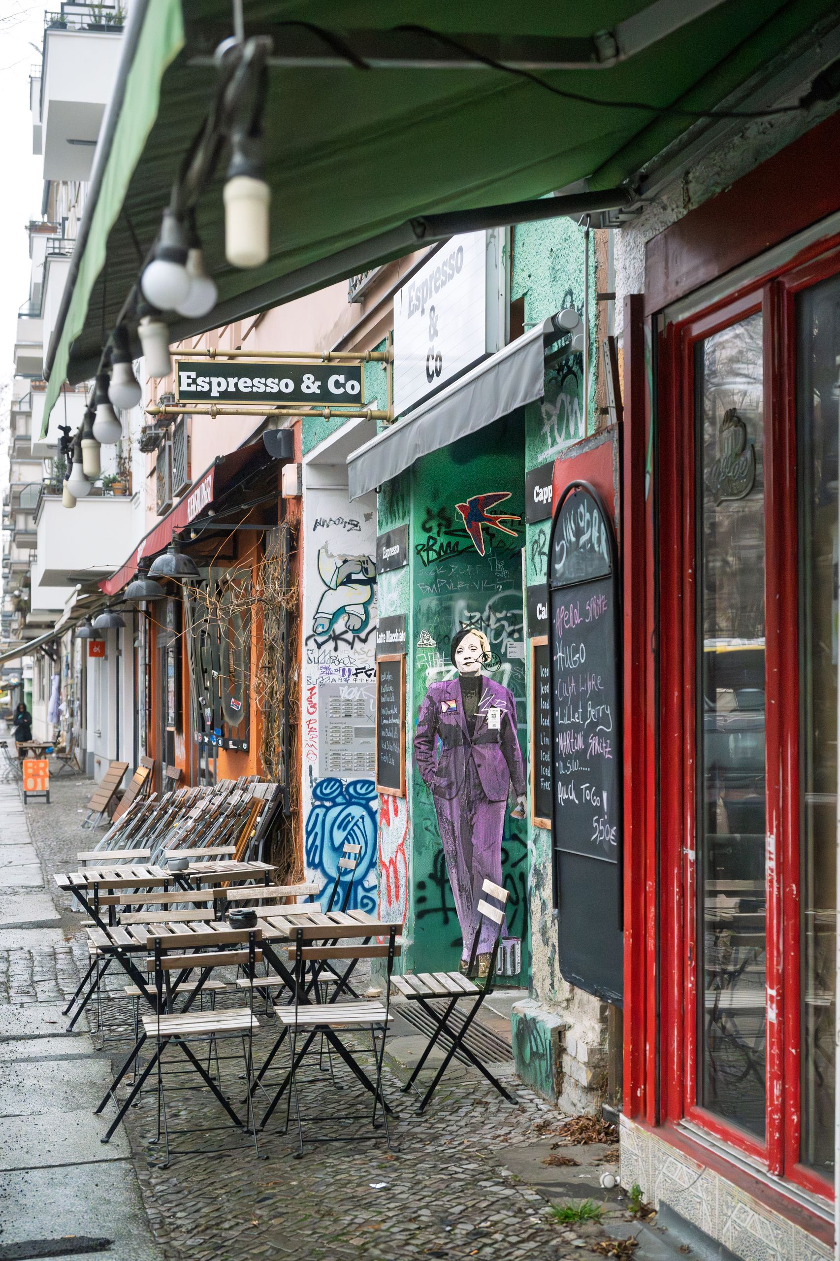Kafégata i Berlin med uteservering, markiser och gatukonst