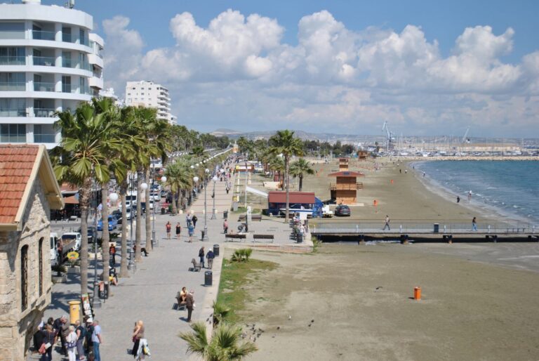 Strandpromenaden Finikoudes i Larnaca med palmer, uteserveringar och sandstrand
