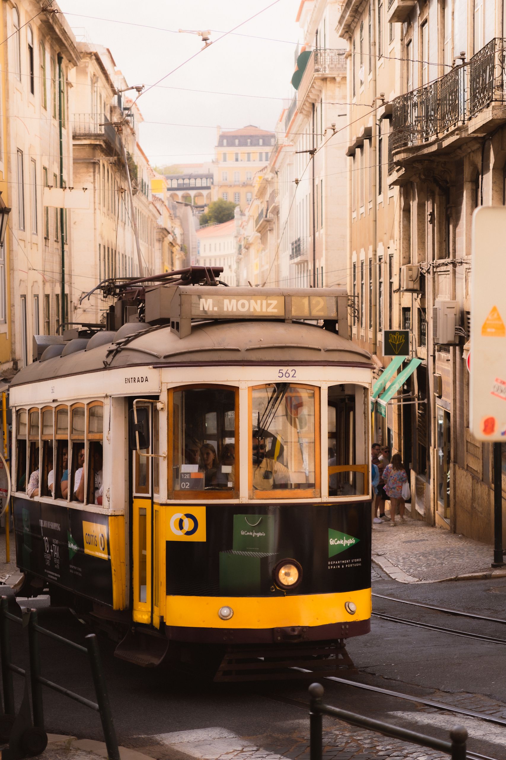 Gul spårvagn på en gata i Alfama i Lissabon